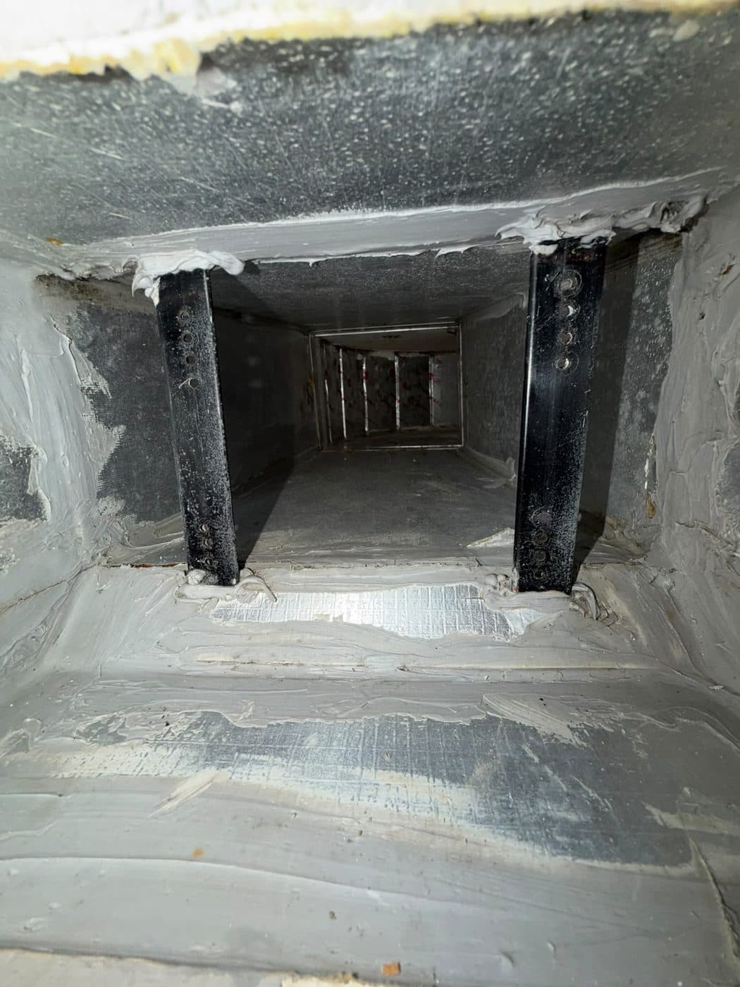 After: the inside of the AC duct cleaned back to bright galvanised metal