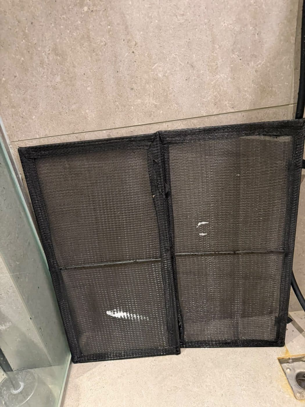 After: two washed AC filters with clear mesh, leaning to drip dry